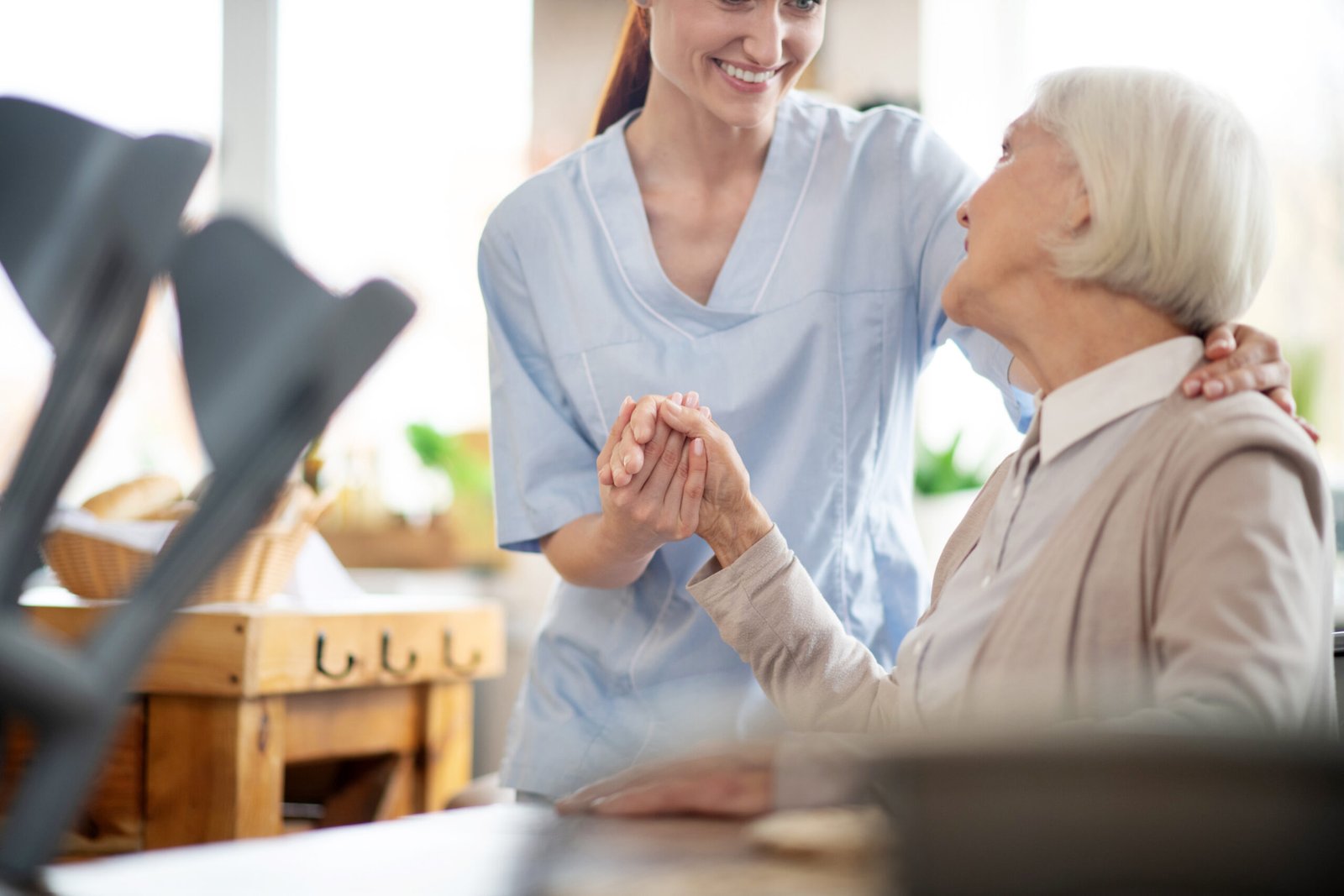 Betreuungskraft in Herne, die eine ältere Dame bei einem Gespräch sanft an der Hand hält